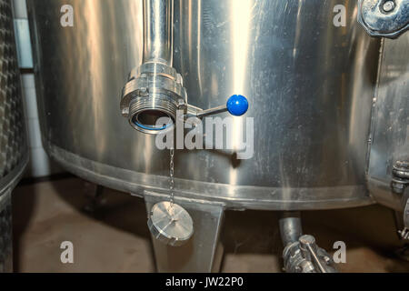 Vicino il vino in metallo serbatoio di fermentazione con svuotamento Foto Stock