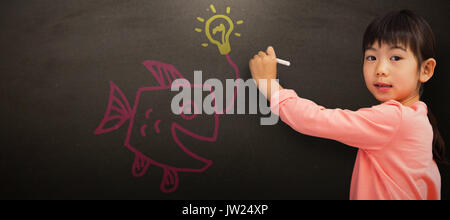 Allievo di disegno con chalk contro di Blackboard Foto Stock