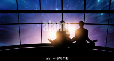 Silhouette uomo e donna facendo la meditazione contro finestre spaziose Foto Stock