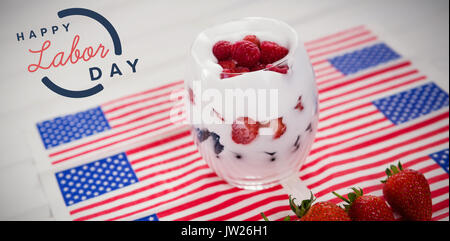 Digital immagine composita di felice Festa del lavoro il testo con contorno blu contro il dessert in vetro su bandierine americane Foto Stock