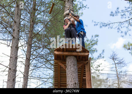 MEZIO, Portogallo - 22 luglio 2017: uomo avventuroso si prepara a una diapositiva in zip fodera attraverso la foresta. Luglio 22, 2017, Mezio, Portogallo. Foto Stock