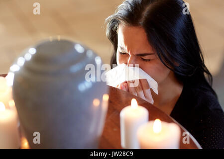 Donna con la cremazione urna al funerale nella chiesa Foto Stock