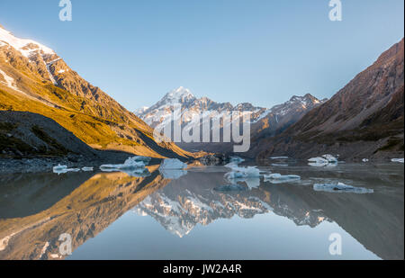 Sunrise, riflessione in Hooker lago, sole di mattina illuminando il Mount Cook, parco nazionale di Mount Cook, Alpi del Sud, Hooker Valley Foto Stock