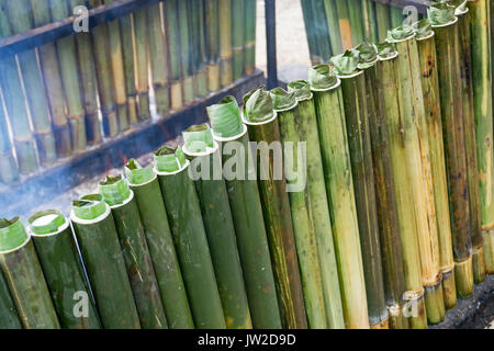 La cottura lemang, un tipo di riso di bambù. Lemang è fatto di riso glutinoso che viene cucinato con latte di cocco in bambù incavate. Si è trovato comunemente in Foto Stock