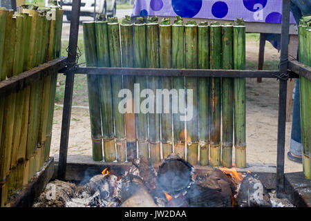 La cottura lemang, un tipo di riso di bambù. Lemang è fatto di riso glutinoso che viene cucinato con latte di cocco in bambù incavate. Si è trovato comunemente in Foto Stock