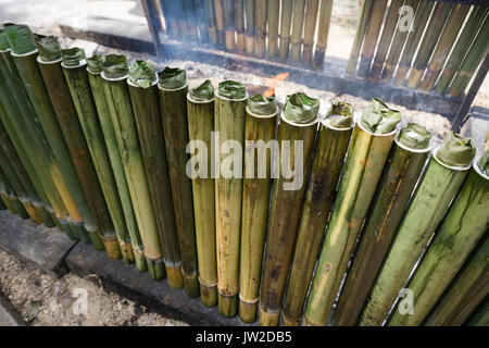 La cottura lemang, un tipo di riso di bambù. Lemang è fatto di riso glutinoso che viene cucinato con latte di cocco in bambù incavate. Si è trovato comunemente in Foto Stock