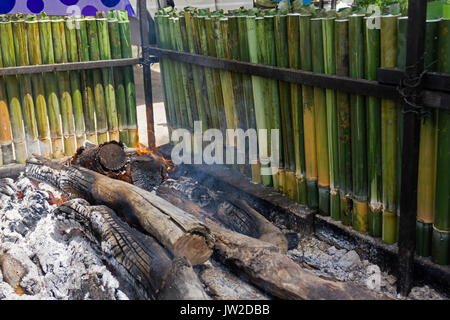 La cottura lemang, un tipo di riso di bambù. Lemang è fatto di riso glutinoso che viene cucinato con latte di cocco in bambù incavate. Si è trovato comunemente in Foto Stock