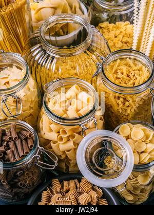 Foto di diversi tipi di pasta in grandi vasi di vetro. Foto Stock