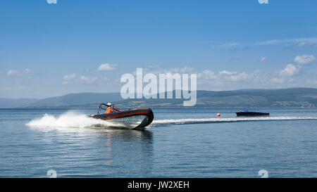 Vista laterale di un Rigid-Hulled barca gonfiabile (RHIB) o barca Rigid-Inflatable (nervatura) imbarcazione a motore / motoscafo / motoscafo / powerboat a girare ad alta velocità a Largs, North Ayrshire, in Scozia, Regno Unito. Azionato da Cumbrae viaggi che offre una varietà di crociere / Visite guidate / passeggiate per i turisti. Modello di Rilascio: No. Proprietà di rilascio: No. Foto Stock