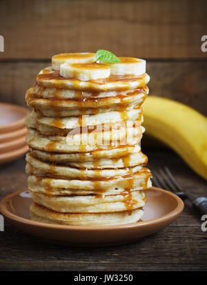 Frittelle di banane,noce per una colazione al buio su un sfondo di legno in stile rustico Foto Stock