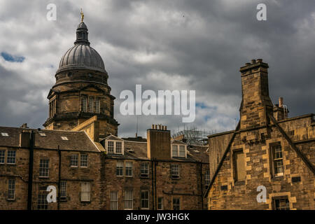 Sommità bombata della vecchia College, Università di Edimburgo con la figura della gioventù dorata statua ornamentali, tenement edifici e cielo drammatico, Scotland, Regno Unito Foto Stock