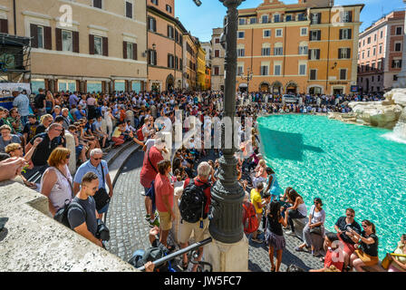 Piazza di Trevi a Roma Italia affollate di turisti di cui gode la Fontana di Trevi in una calda giornata estiva Foto Stock