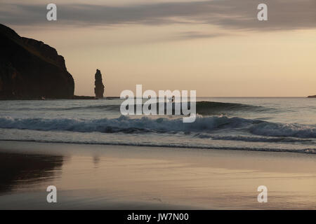 Surfer in tarda serata, la posizione è Sandwood Bay in NW Scozia. Foto Stock