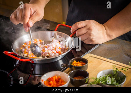Lo chef è la frittura ingrediente alimentare per la cottura di paella. Foto Stock