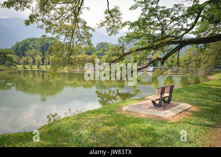 Panca e acqua riflessioni di Taman Tasik, aka giardini del lago, nella città di Taiping, stato di Perak, Malaysia Foto Stock