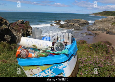 Cumulo di rifiuti di plastica pulito da Killintringan spiaggia di Dumfries e Galloway con la spazzatura in primo piano e beach e blue skies in background Foto Stock