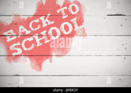 Si torna a scuola del testo in verde e blu splash contro il legno bianco Foto Stock