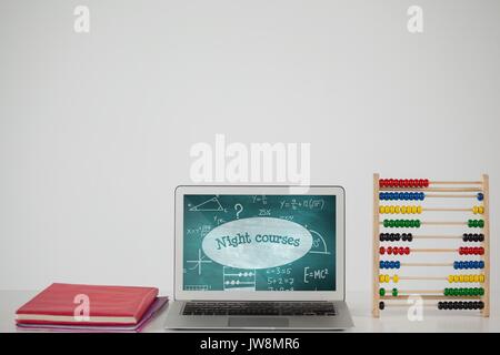 Composito digitale del computer su una tavola di scuola con la scuola le icone sullo schermo Foto Stock