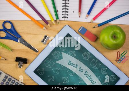 Digital composito della tavoletta su una tavola di scuola con la scuola le icone sullo schermo Foto Stock