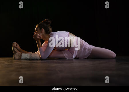 Femmina ballerina stretching prima di ballare in studio Foto Stock