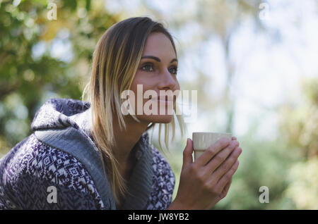 Close up di pensosa escursionista femmina che guarda lontano mentre avente bere Foto Stock