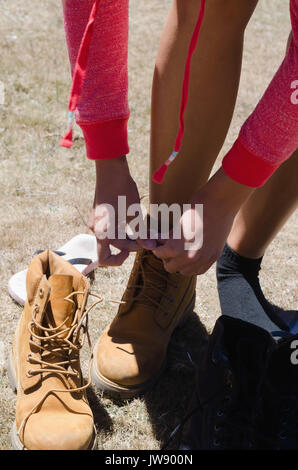 Elevato angolo di visione femminile di escursionista passalacci di legatura mentre si sta in piedi sul campo Foto Stock