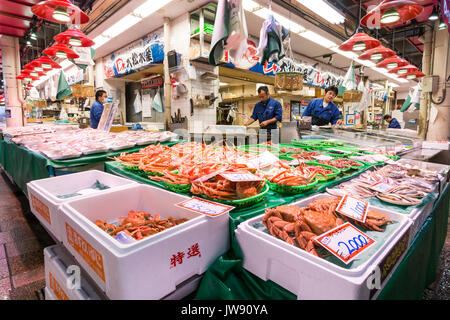 Contenitori riempiti con arance grandi granchi sulla vendita di pesce-mercanti di stallo nella piscina di alimenti freschi di mercato, Omicho, Kanazawa, Giappone. Foto Stock