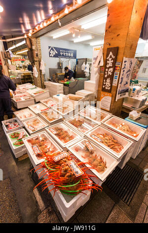 Piatti a base di frutti di mare freschi stallo con vari tipi e dimensioni di granchi in contenitori per la vendita nel mercato coperto, Omicho, a Kanazawa, Giappone. . Foto Stock