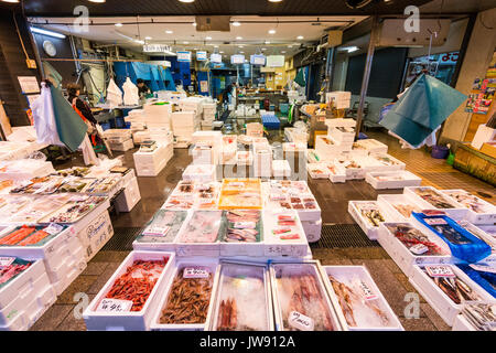 Giappone, Kanazawa. Omi-cho cibo fresco il mercato coperto. Pesce fresco in stallo. Vista lungo, display di vari pesci in contenitori. Foto Stock