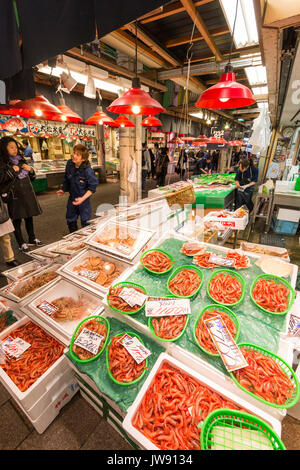 Gamberetti, nel verde di cestelli in plastica e granchi sulla vendita in stallo nella famosa Omicho piscina fresca di mercato alimentare a Kanazawa, Giappone. Alcune persone. Foto Stock