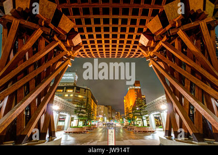 Landmark Tsuzumi gate, aka porta a tamburo, a Kanazawa stazione ferroviaria del Giappone. Notte tempo dopo la pioggia. Vista dall'interno cupola di vetro e alla strada principale. Poche persone Foto Stock