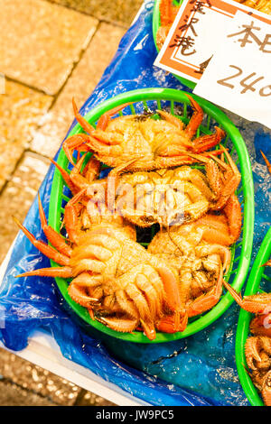 Giappone, Kanazawa. Omi-cho cibo fresco il mercato coperto. Pesce fresco in stallo. Contenitore pieno di granchi in vendita. Foto Stock