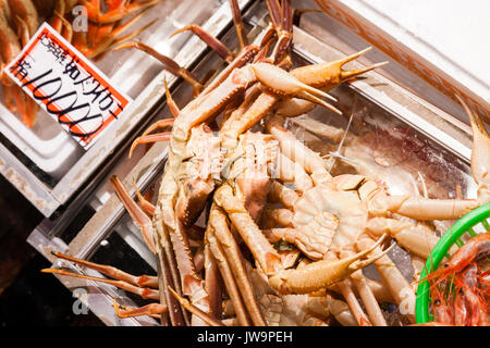 Giappone, Kanazawa. Omi-cho cibo fresco il mercato coperto. Pesce fresco in stallo. Granchi in contenitori per la vendita a 10.000 yen Foto Stock