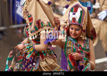 Llamerada ballerini in costumi ornati di eseguire come sfilano attraverso la città mineraria di Oruro sull'altipiano della Bolivia durante il carnevale annuale Foto Stock