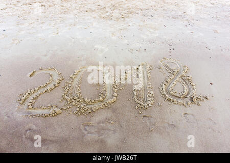 2018 scritto di sabbia su una spiaggia al tramonto. Anno nuovo Foto Stock