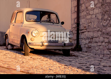 Vintage Fiat 500 parcheggiato in strada di una città medievale. L'Italia, 2011. Formato orizzontale. Foto Stock