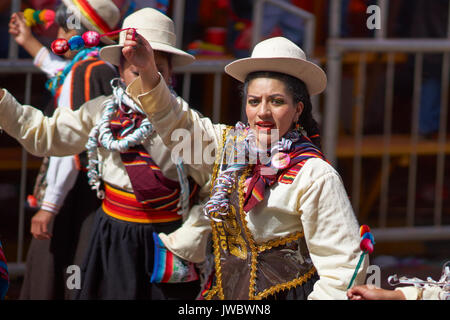 Llamerada ballerini in costumi ornati di eseguire come sfilano attraverso la città mineraria di Oruro sull'altipiano della Bolivia durante il carnevale annuale Foto Stock