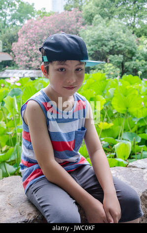 Ritratto di un giovane ragazzo nel parco della gente in Cina a Shanghai. Foto Stock
