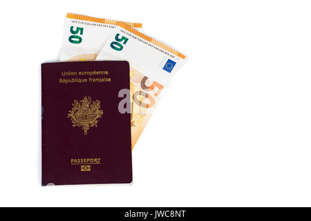 100 euro bills banconote inserite tra le pagine del francese europeo passaporto. Concetto di viaggio di prezzo, backchich. Vista anteriore e superiore, close-up Foto Stock