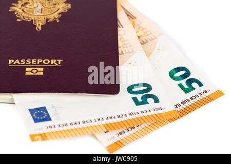100 euro bills banconote inserite tra le pagine del francese europeo passaporto. Concetto di viaggio di prezzo, backchich. Vista anteriore e superiore, close-up Foto Stock