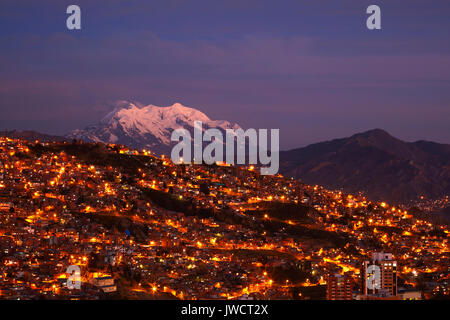 Ultima luce su Illimani (6438m/21,122ft) e le luci di La Paz, Bolivia, Sud America Foto Stock