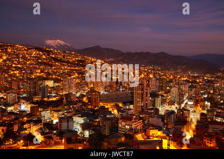 Ultima luce su Illimani (6438m/21,122ft) e le luci di La Paz, Bolivia, Sud America Foto Stock