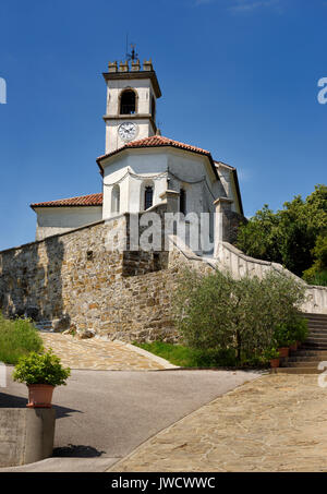 Bianco chiesa cattolica di San Leonardo con la catena e il clock belfry in Dolnje Cerovo Gorica colline Brda Slovenia Foto Stock