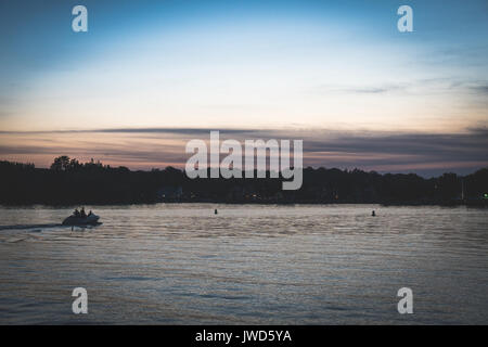 Sunset over kayakers sulle sponde di un lago in Upstate New York Foto Stock