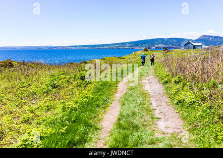 Perce, Canada - 6 Giugno 2017: la gente giovane camminando sul sentiero dall' oceano costa scogliera sulla Bonaventure Island in Quebec, Canada da Gaspesie, Gaspe regione Foto Stock