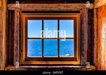 Guardando attraverso la vecchia finestra rustico di casa con vista oceano nella isola di Bonaventura, Quebec, Canada Foto Stock