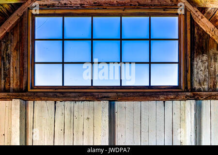Guardando attraverso la vecchia finestra rustico di casa con vista oceano nella isola di Bonaventura, Quebec, Canada nel fienile Foto Stock