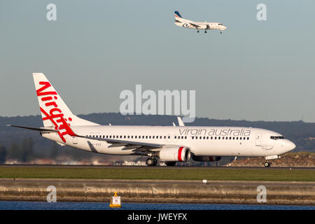 Virgin Australia Airlines Boeing 737-800 aeromobili all'Aeroporto di Sydney con un REX Saab 340 sbarco dietro. Foto Stock