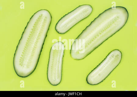Fette di cetriolo in plastica verde tagliere vista superiore Foto Stock