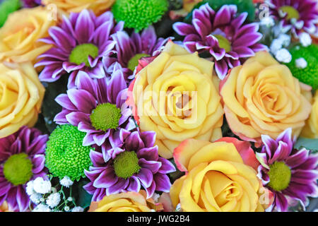 Un grosso mazzo di fiori di un bel colore giallo le rose e i crisantemi viola. Presentato da vicino, vista dall'alto. Foto Stock
